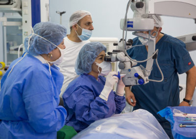Dr. Mireille Hamparian operating on an eye cataract case while Stepanakert ophthalmologists closely follow with the side microscopes.