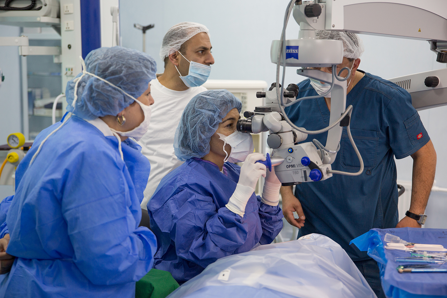 Dr. Mireille Hamparian operating on an eye cataract case while Stepanakert ophthalmologists closely follow with the side microscopes. 